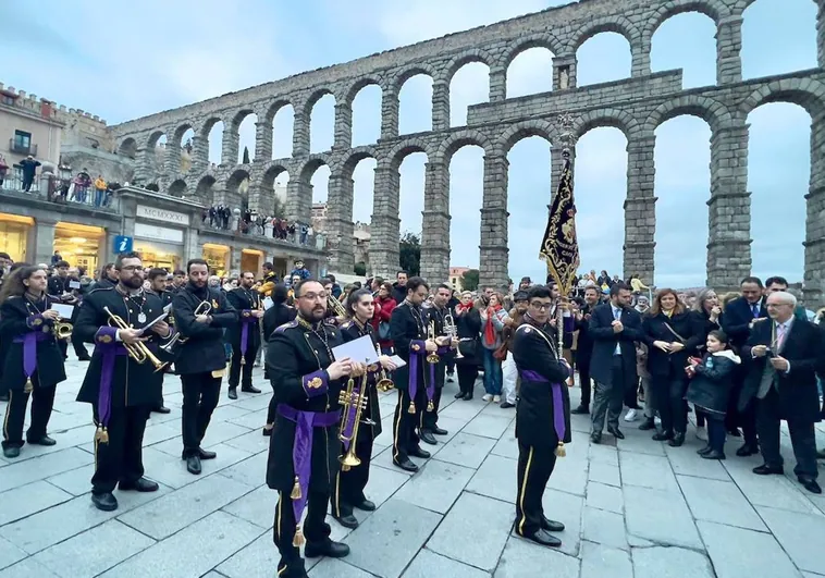 La agrupación musical Nuestra Señora de la Misericordia desfila ante el acueducto y la delegación cacereña desplazada hasta Segovia.