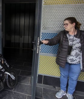 Imagen secundaria 2 - Arriba, Laura Escobar, en la peluquería, con una clienta. Abajo, Antonio García, cliente del hogar de mayores, se dispone a abonar su consumición, ya con luz en el local. Abajo, una vecina abre la puerta del negocio.