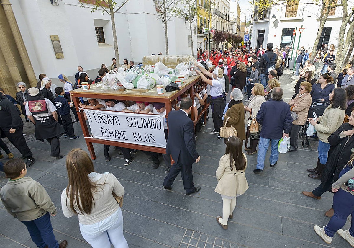 Los costaleros animan a llenar el paso de alimentos para los comedores benéficos.