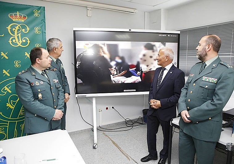 Mandos de la Guardia Civil y el delegado del Gobierno en Extremadura viendo un vídeo de la liberación de cinco jóvenes.