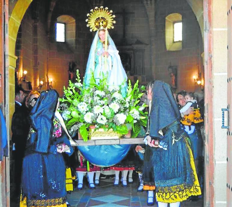 Las jóvenes sacan a la imagen de la Virgen en procesión.