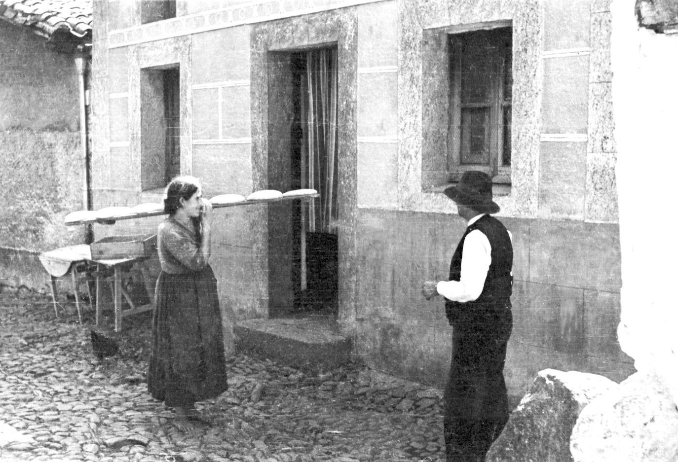 Una mujer descalza llevando masa de pan para hornear. La fotografía es muy parecida a una que hizo Eugene Smith en Deleitosa, que se publicó en la revista Life en 1952.