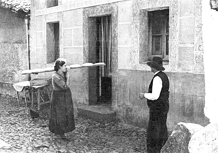 Mujer descalza llevando masa de pan para el horno.