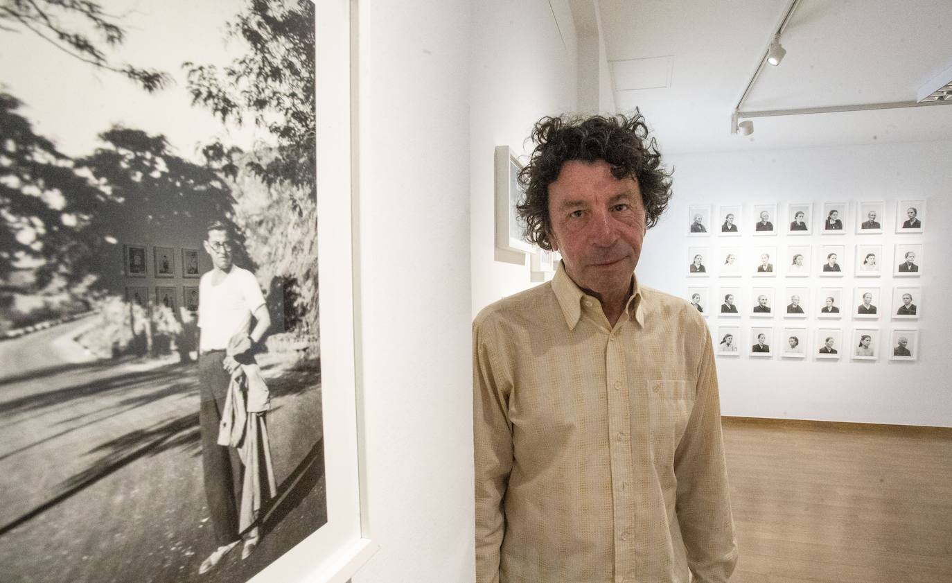 Genín Andrada, comisario de la exposición ‘Remigio Mestre y la mujer extremeña en los años del silencio’, junto a una imagen en la que el fotografiado es Mestre.