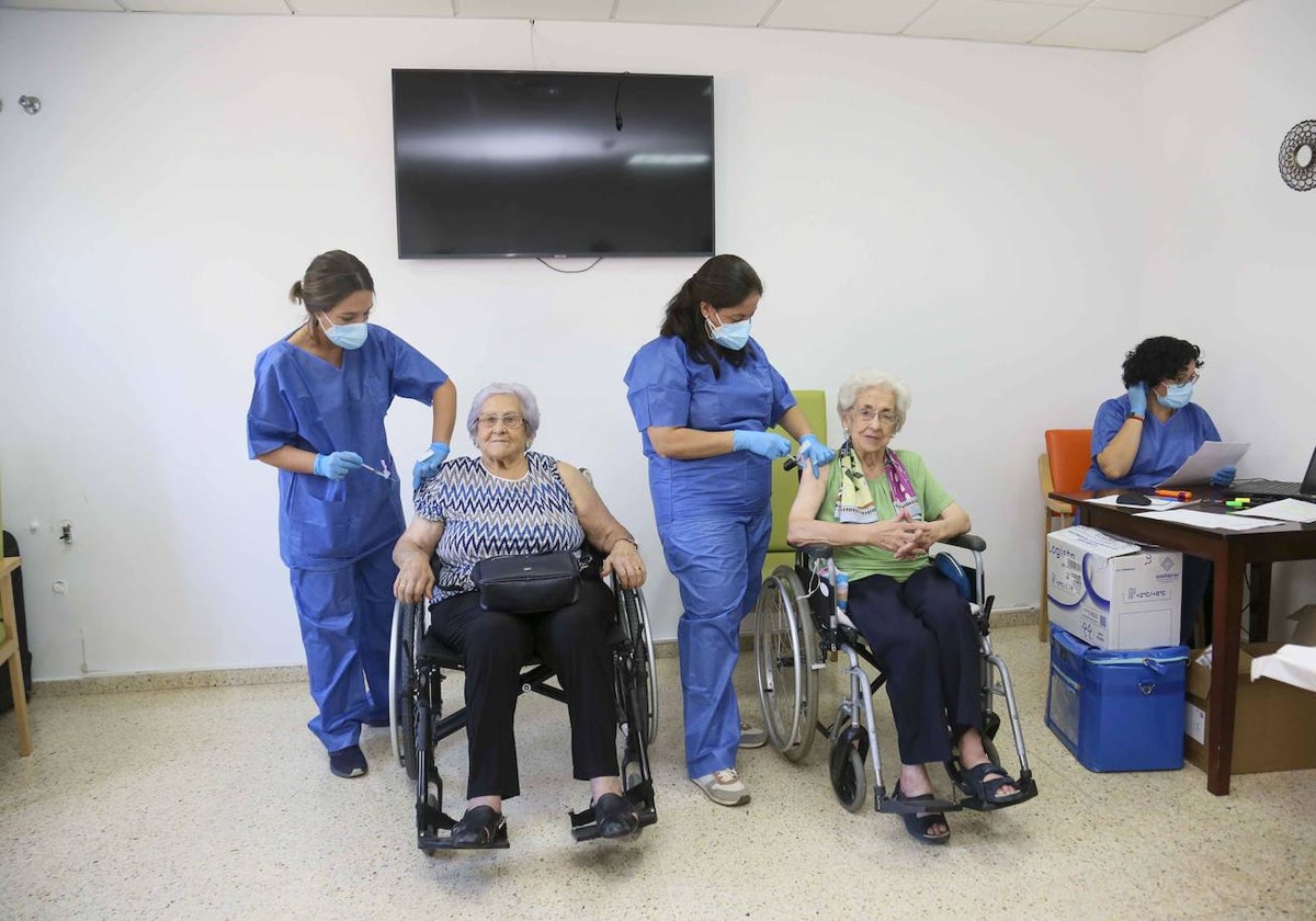 Dos mujeres recibiendo la cuarta vacuna contra la covid, en la residencia de Arroyo de San Serván.