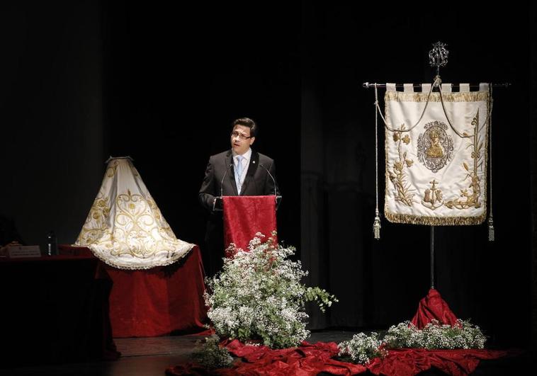 Ismael López este miércoles en el Gran Teatro entre un manto de la Virgen y un estandarte de la cofradía.