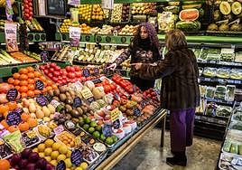 Dos señoras comparan el precio de la fruta en un supermercado