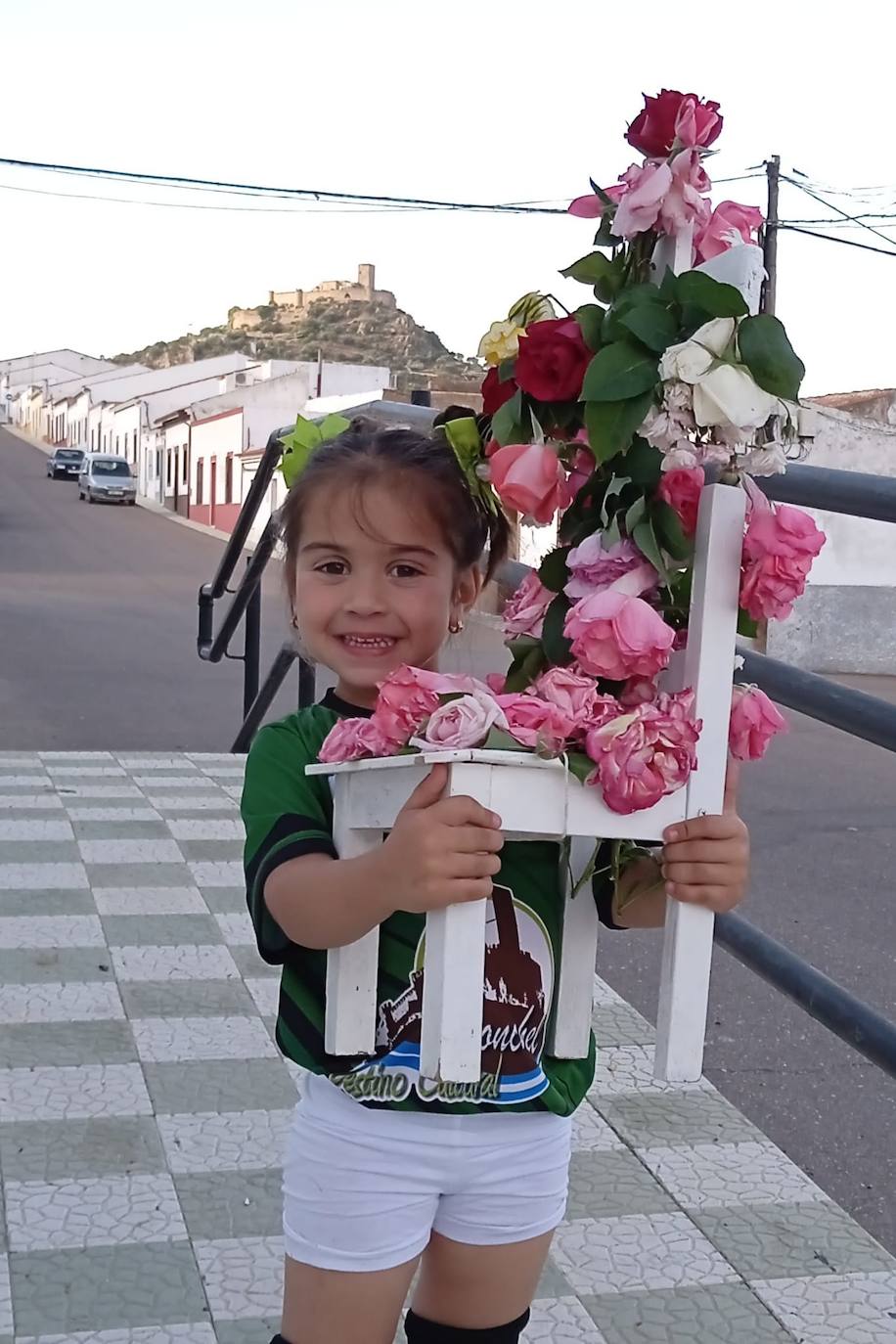 Imagen secundaria 2 - Arriba, mujeres de la asociación 'Amanecer', con su cruz hecha con flores de bolsas de plástico. Abajo, componentes de la asociación 'La Esperanza' con su cruz, y la niña Marina García Correa, con una cruz tradicional en silla.