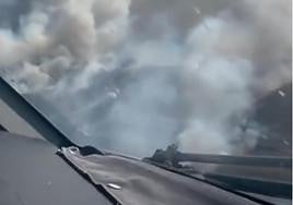 Columna de humo del incendio vista desde el interior de un medio aéreo.