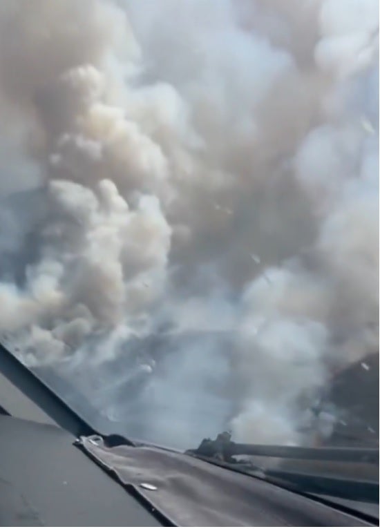 Columna de humo del incendio vista desde el interior de un medio aéreo.