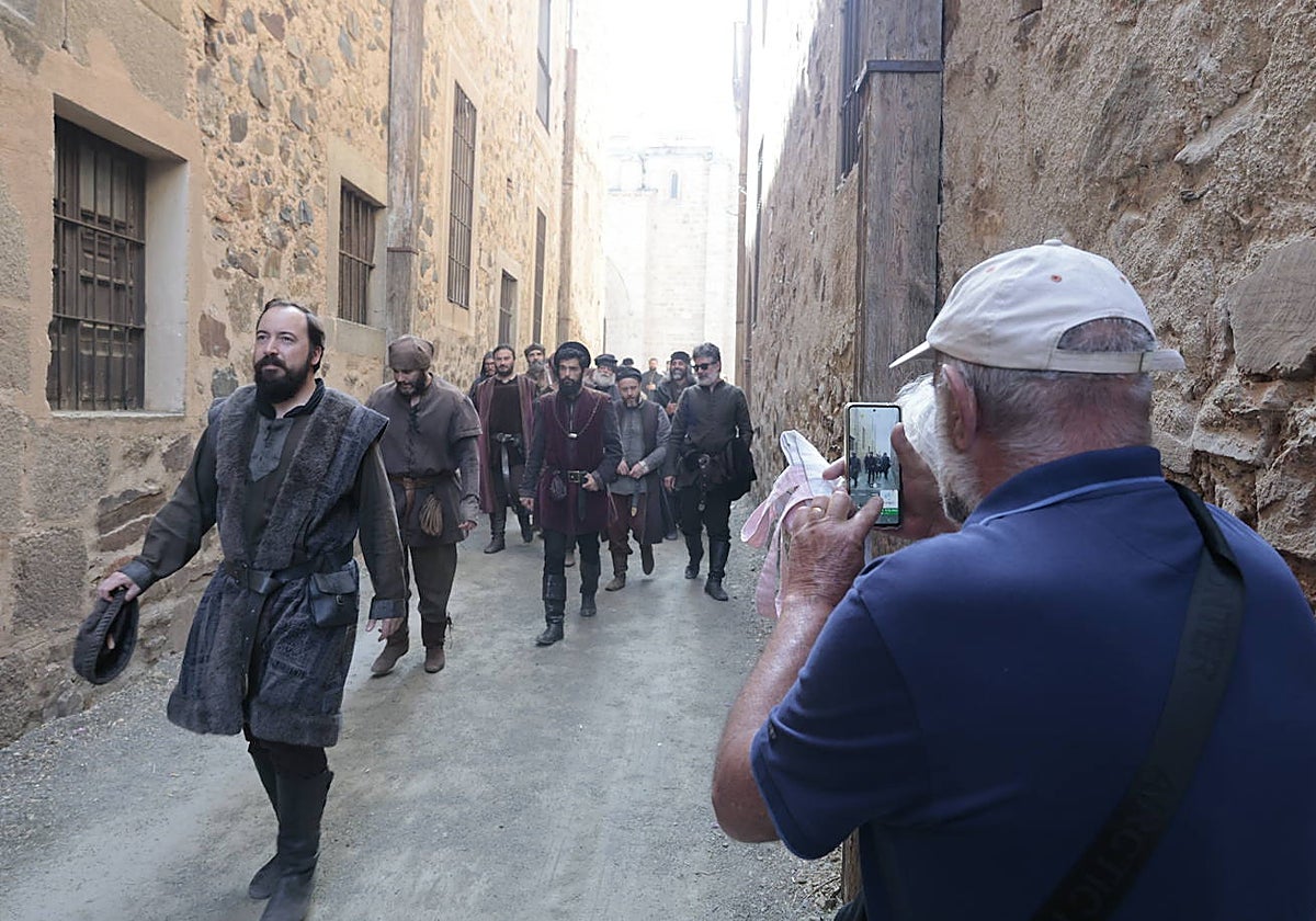 Un turista aprovecha la salida de los actores y figurantes de la plaza de Santa María para hacerles una fotografía.