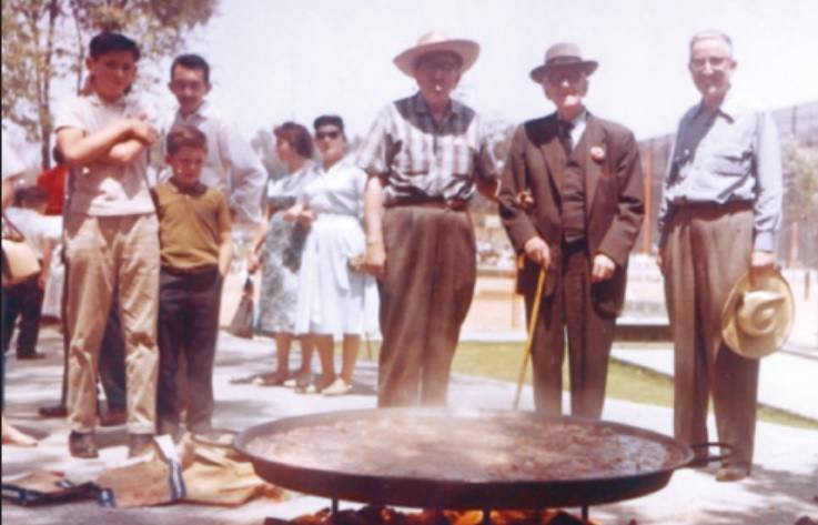 Manuel Castillo con sus hijos Luis y Diego en México en 1962, preparando una paella con otros exiliados españoles.