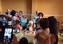 Cecilia soplando las velas con toda su familia.