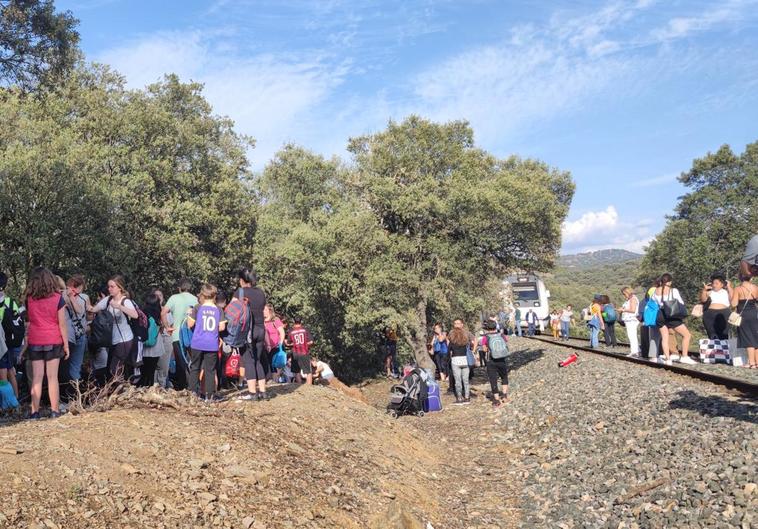 Pasajeros junto a las vías tras bajarse del tren averiado entre las estaciones de Guadalcanal y Cazalla, en la Sierra Norte de Sevilla.