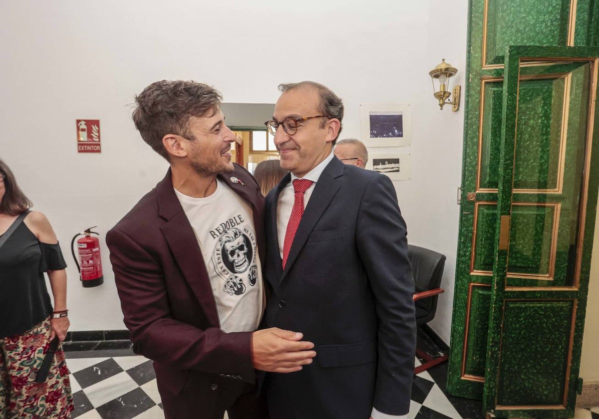 El concejal socialista David Santos, con camiseta del Redoble, y el alcalde Rafael Mateos, se abrazan tras la toma de posesión de esta mañana.