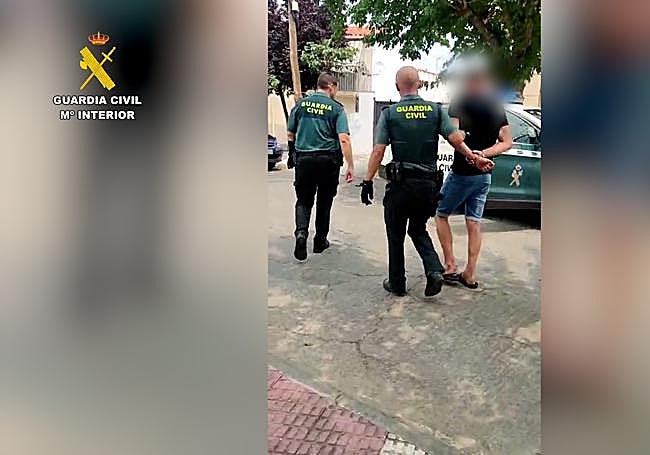 El detenedio es conducido al vehículo de la Guardia Civil