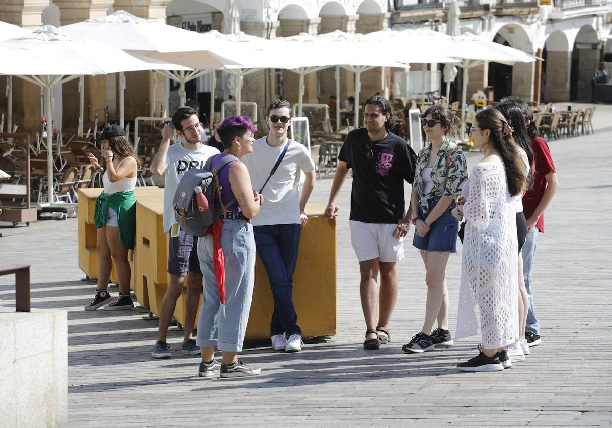 Un grupo de turistas durante una visita guiada en la Plaza Mayor de Cáceres.