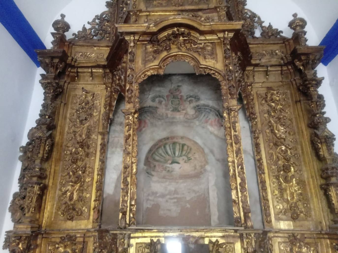 Imagen secundaria 2 - Arriba, mural recién sacado del horno, visto frontalmente. Abajo, detalle durante su fase de elaboración, y panorámica del retablo de madera con la hornacina antigua con los restos de pinturas orginales.