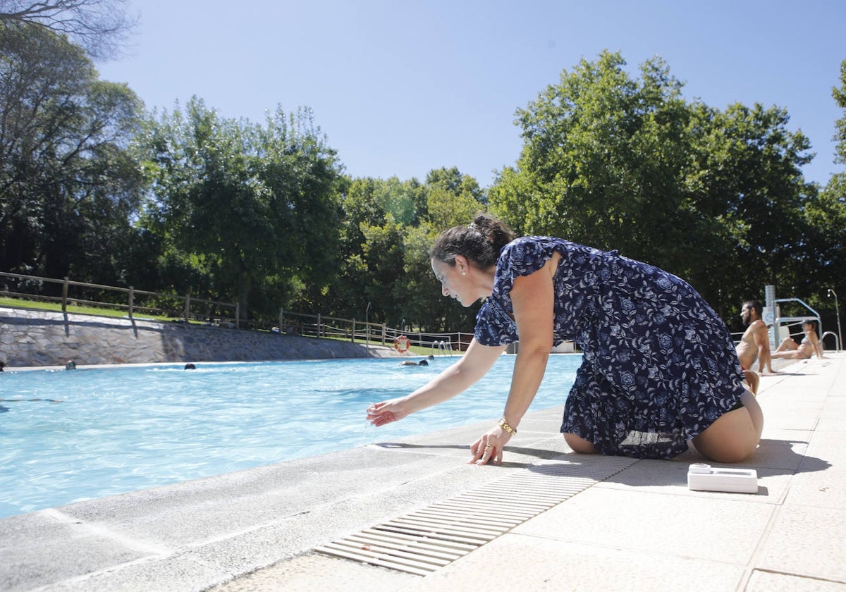 Cristina Sánchez, de la empresa Conyser, toma una muestra en la piscina del parque del Príncipe, en Cáceres.