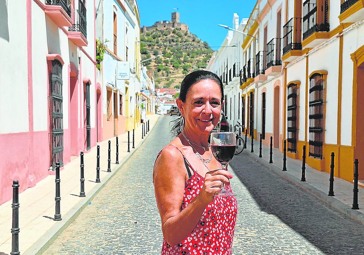 María Julia Marín sujeta una copa de vino con el castillo de Miraflores como telón de fondo.