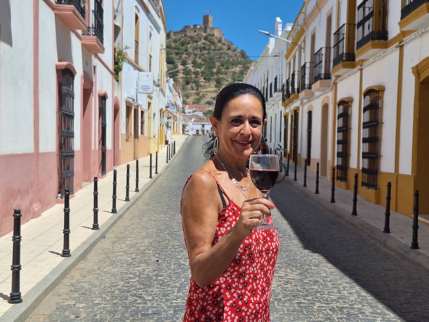 María Julia Marín sujeta una copa de vino con el castillo de Miraflores como telón de fondo.