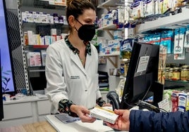 Una farmacéutica dispensa un test a un cliente.