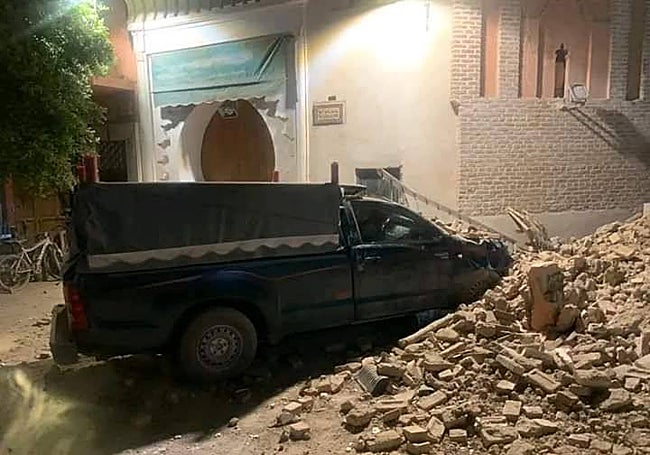 Furgoneta junto a una pared derrumbada.