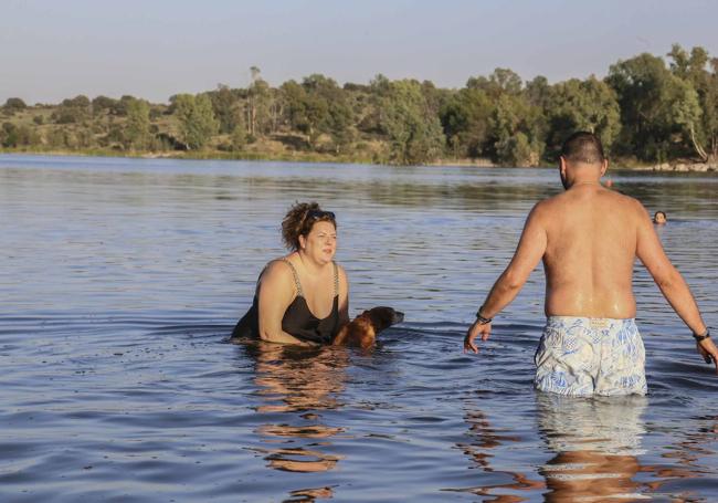 Ana, su perro y su pareja, que viven en Los Alpes suizos, se bañan el jueves pasado en el embalse de Proserpina, en Mérida.