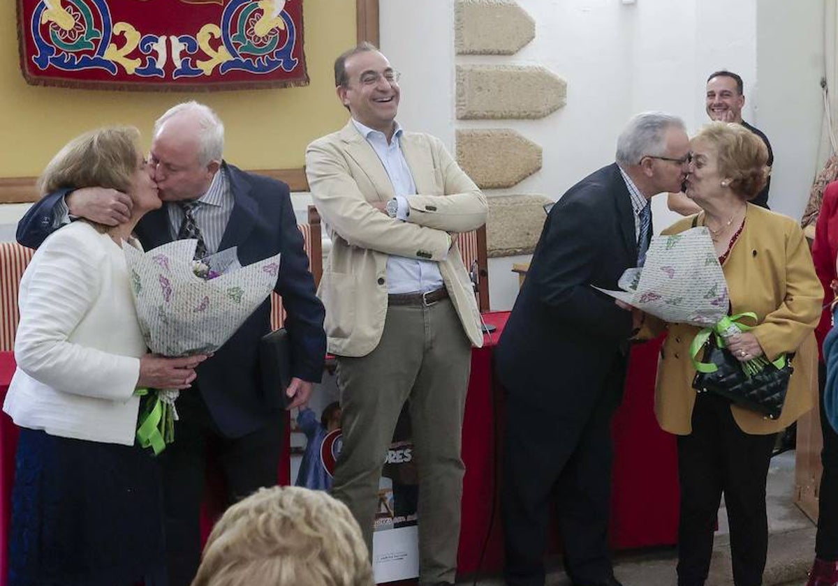 El alcalde sonríe mientras las dos parejas se besan; a la izquierda la de las bodas de oro (51 años) y a la derecha las de diamante (60 años).