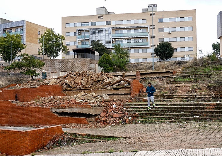 Un vecino baja una escalera en el parque, entre ripios y jaramagos.