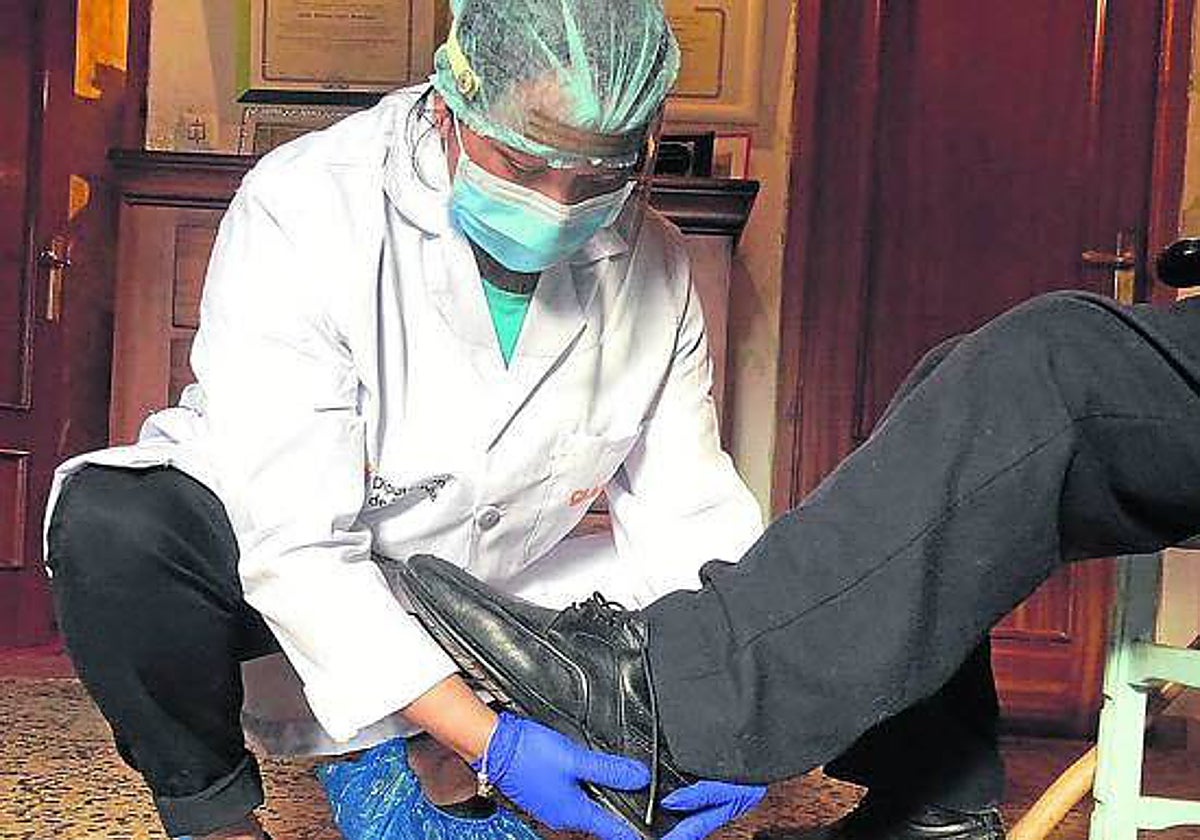 Imagen de archivo de una trabajadora de ayuda a domicilio atendiendo a un mayor.