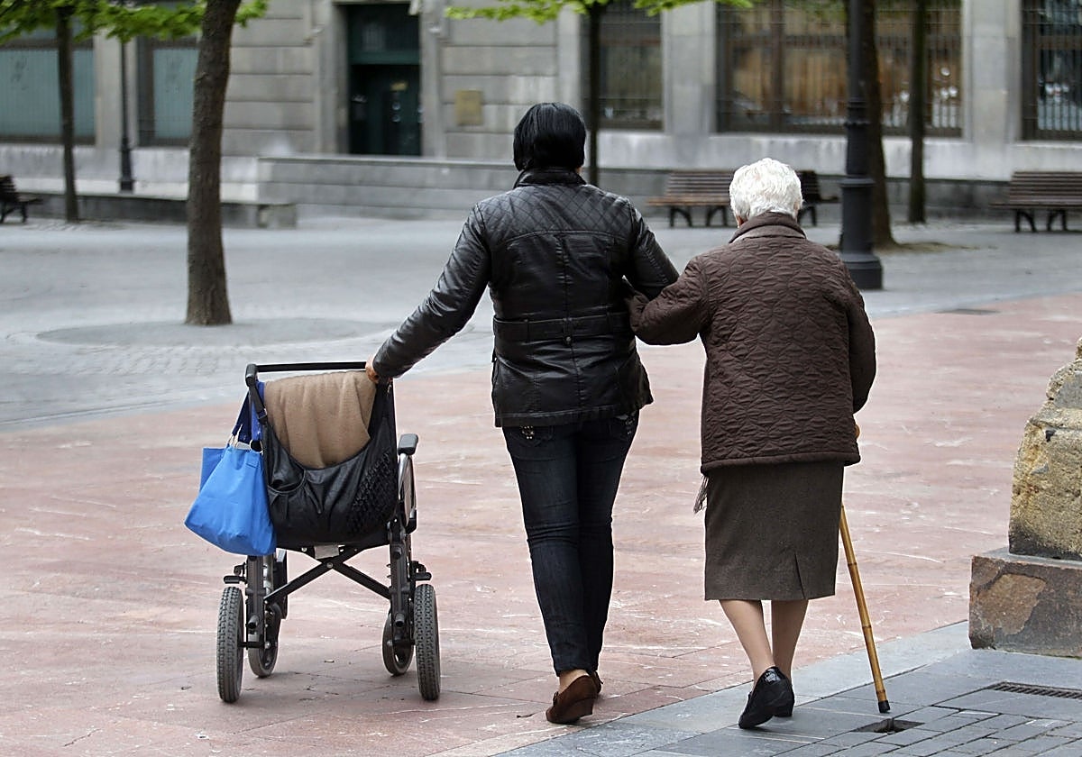 Una cuidadora acompaña a una mujer dependiente en una imagen de archivo.