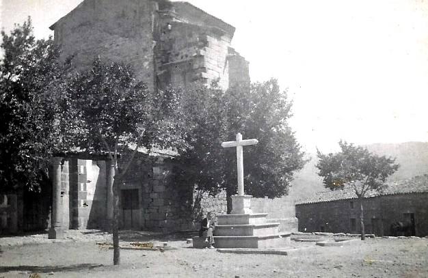 Fotografía de alrededor de los años 60 de una cruz de piedra de Valverde del Fresno junto a la iglesia de Nuestra Señora de la Asunción.