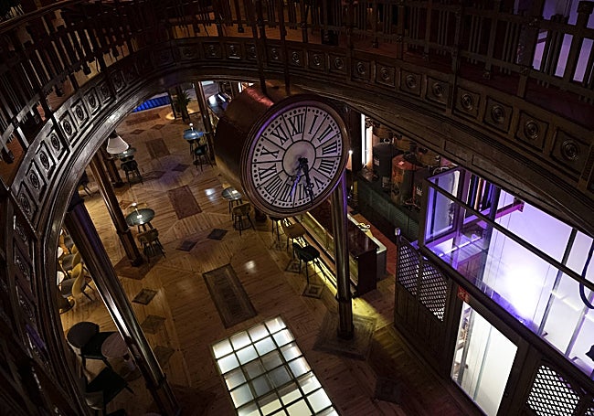 Un agujero ovalado atraviesa todo el edificio de madera, por donde asoma un reloj.