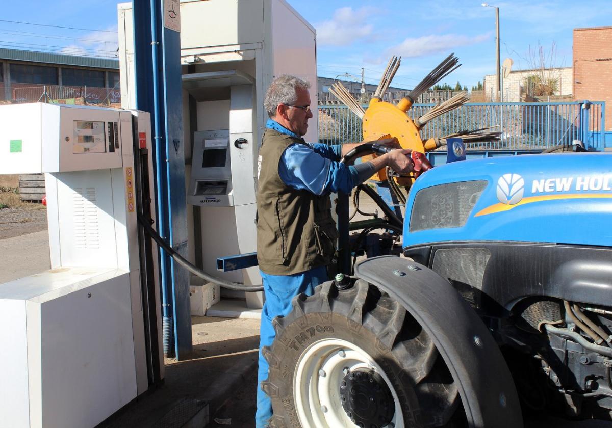 Un agricultor reposta con su tractor en la estación de servicio de una cooperativa.