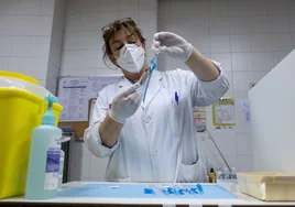 Una enfermera prepara una vacuna en un centro de salud.