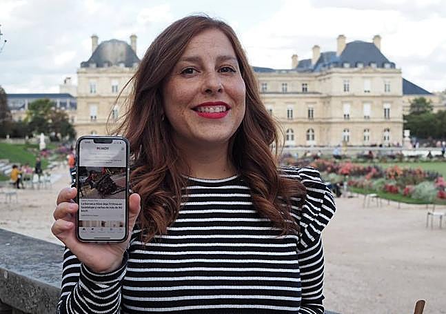 Elena García en París mostrando la aplicación del HOY por la que consulta las noticias.
