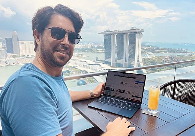 Álvaro Morcillo leyendo HOY.es con el hotel Marina Bay Sand de Singapur al fondo.