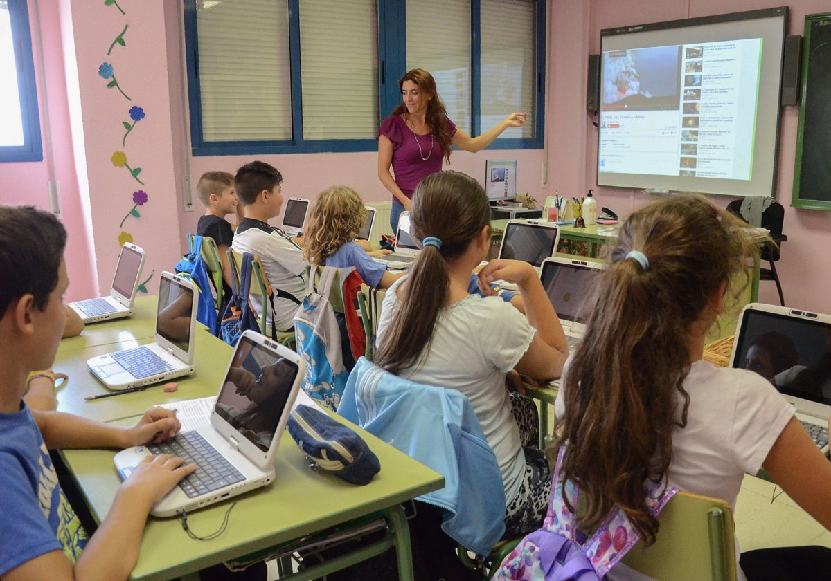 Alumnos con portátiles y pizarra digital en un aula extremeña.