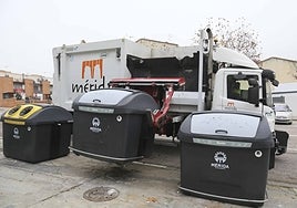 Un operario del servicio de recogida de basura retira un contenedor.