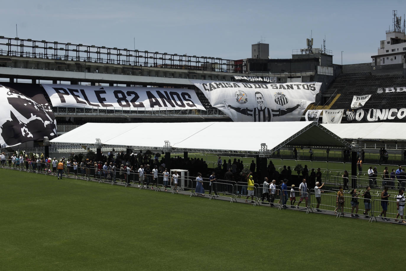 Cientos de personas hacen cola para asistir al velorio de Pelé en el estadio del Santos. 