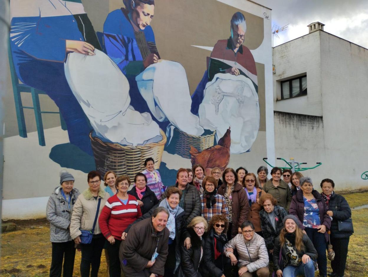 Mujeres de la poblaciónfrente al mural dedicado alas costurera. 