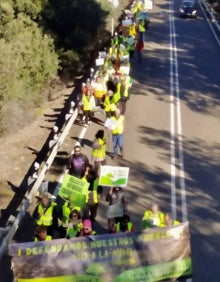 Imagen secundaria 2 - Mensajes contra el proyecto minero en la imagen superior. Abajo, algunos manifestantes con sus pancartas por la carretera y vehículos que han hecho el recorrido desde Holguera. 