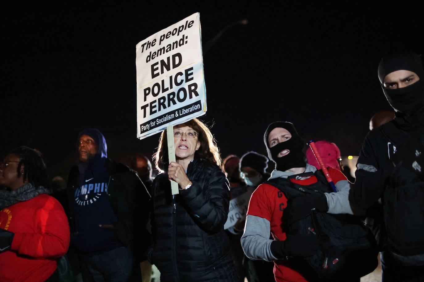 Una mujer sostiene un cartel que pide el fin del terror policial
