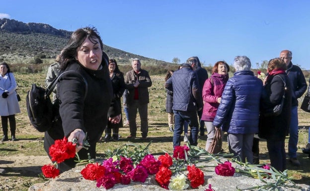 Una familiar de un desaparecido extremeño en Orduña deposita claveles en los que fue el campo de concentración de Castuera. 