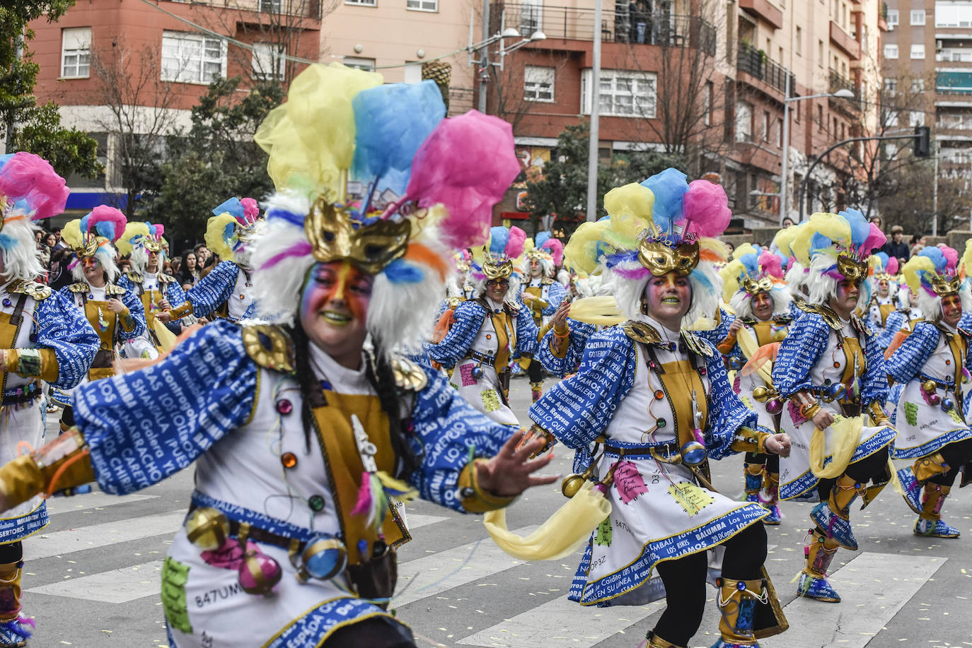 Balumba tiene una propuesta muy original este año, la locura del Carnaval. Son una especie de científicos locos llenos de elementos carnavaleros. Sus camisas llevan impresas los nombres de todas las comparsas y las murgas de la fiesta y en su traje hay detalles propios de un adicto a esta celebración como la turuta o la brillantina. Su gorro simula una peluca de científico loco pero con antifaz y plumas. Además se les ve un cerebro de colores con ideas carnavaleras. Muy divertidos. 