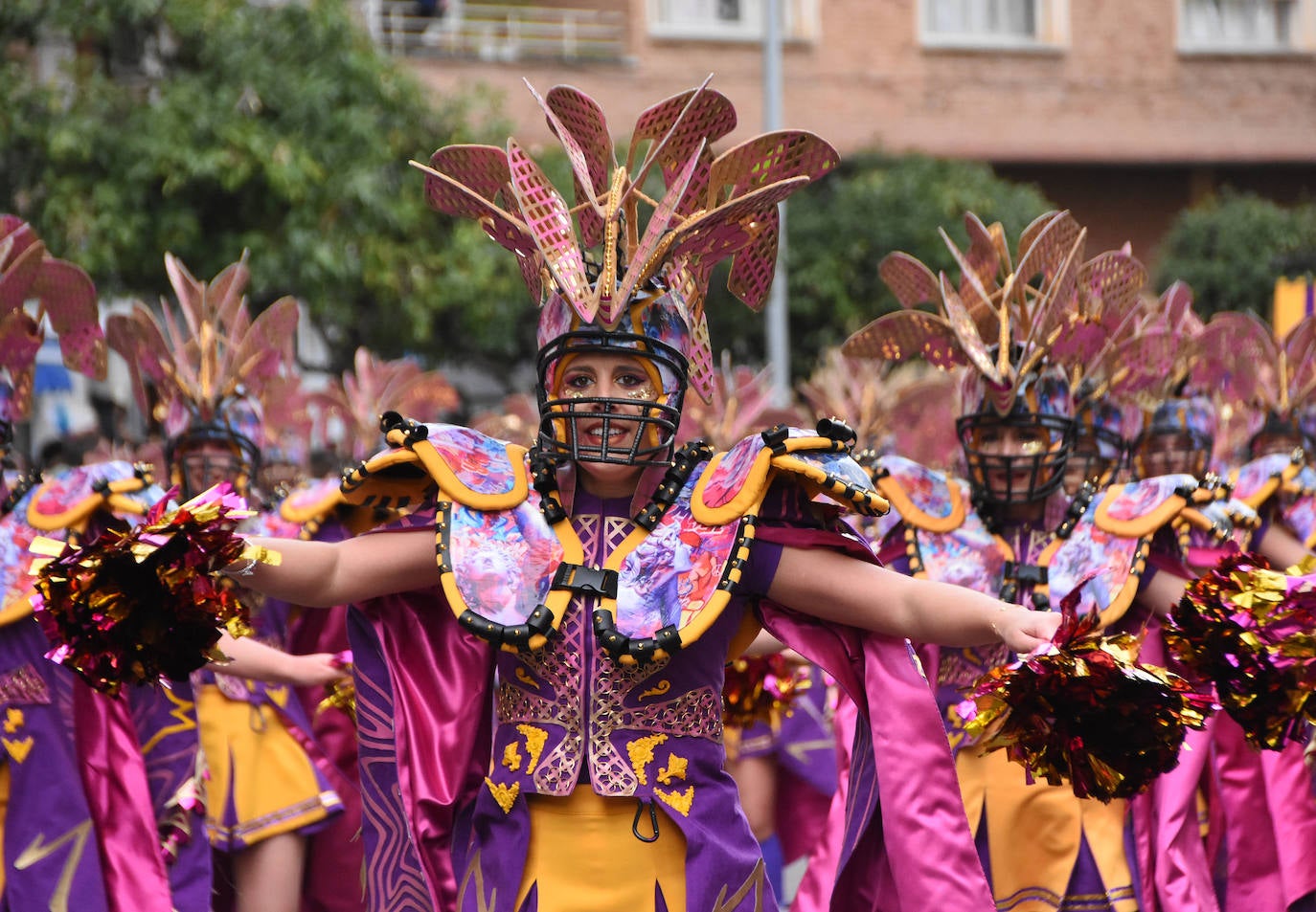 En amarillo y morado han desfilado Las Monjas. Como es tradicional en esta comparsa de Torremejía, mezcla dos temáticas en sus trajes, en este caso, el fútbol americano con las justas medievales. Los detalles brillantes de su gorro, siempre muy complejo, les hizo lucirse. El montaje de 2023 recuerda algunas de las mejores propuestas de esta comparsa que sabe lo que es ganar siete veces en Badajoz.