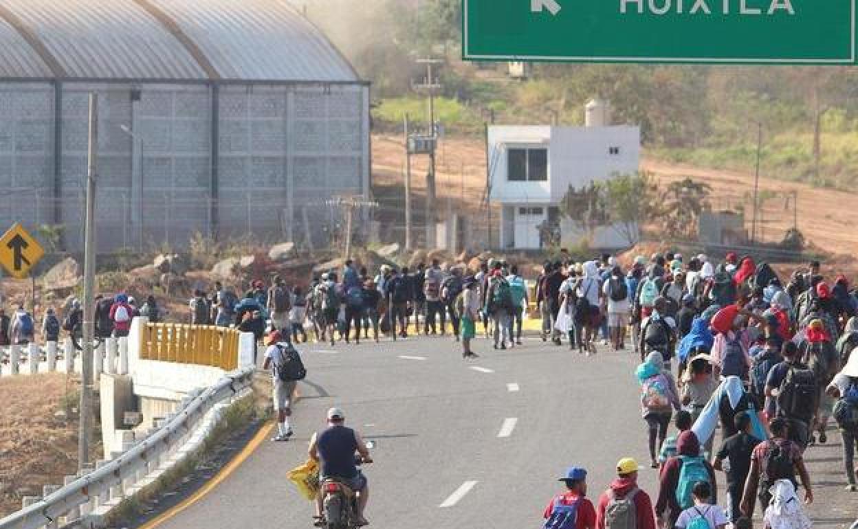Migrantes caminan por una carretera de la ciudad de Huixtla, en el sur de México, con destino a la frontera con Estados Unidos