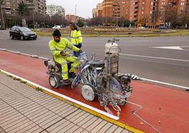Los trabajadores de la empresa pintan el carril bici a su paso por Sinforiano Madroñero.