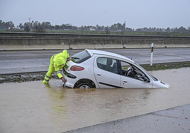Coche en mitad de una balsa de agua en la BA-20, a la altura de la venta Don José.